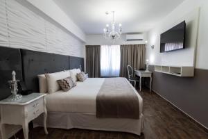 布宜诺斯艾利斯Ker San Telmo Hotel的一间卧室配有一张床、一张书桌和一台电视