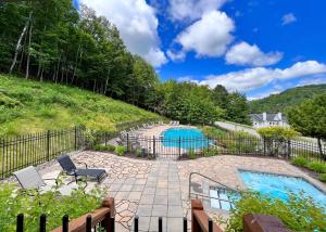 蒙特朗布朗Le PanoramiK by Gestion ELITE的后院设有游泳池和围栏