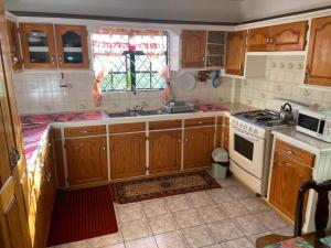 格罗斯岛Homely environment ideal for a home away from home的厨房配有木制橱柜和炉灶烤箱。