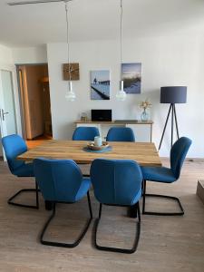 青斯特Meehrblick App 215的一间带木桌和蓝色椅子的用餐室