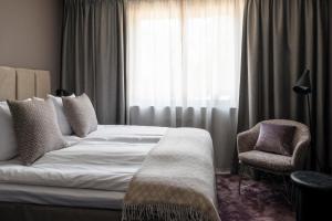 利丁厄洛维克别墅酒店的卧室配有床、椅子和窗户。