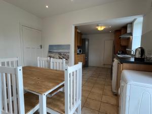 都柏林Sandymount House & Garden的厨房以及带木桌的用餐室。