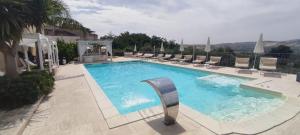 SantʼOmeroAnthos Casa Vacanze的周围设有大型游泳池,配有躺椅