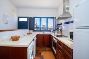 塞博河畔卡莱塔Eslanzarote El Ancla House, wifi, Sea views的厨房配有木制橱柜和白色台面