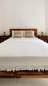ApérathosLaina Traditional Guest House的一张配有白色床单和枕头的大床