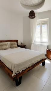 ApérathosLaina Traditional Guest House的一间白色的卧室,房间内设有一张木床