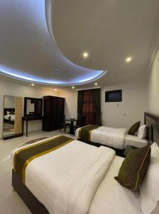 达曼Arrawiya Alzahabia Hotel的酒店客房设有两张床和圆形天花板。