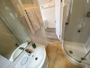 伦敦Cosy flat in London的浴室配有白色水槽和淋浴。