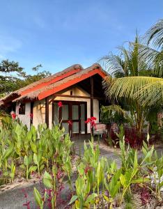 塞隆贝拉纳克Burudika Bungalows的一座有红色屋顶和一些植物的房子