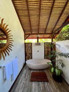 塞隆贝拉纳克Burudika Bungalows的带浴缸的浴室和屋顶