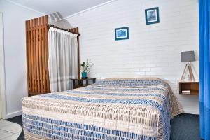 多尔比米亚尔汽车旅馆的一间卧室配有一张带蓝白色毯子的床