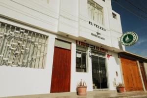 帕拉卡斯Hospedaje El Velero的街上有红色门的白色建筑