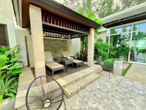 迈考海滩Sunset Ocean Front Villa , Mai Khao Phuket的房屋设有带桌椅的庭院