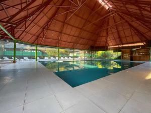 马尔多纳多港Ecoamazonia Lodge的一座带屋顶的建筑中的一个大型游泳池
