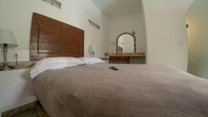 迪坡斯特兰La Buena Suerte的一间卧室配有一张大床和大型木制床头板