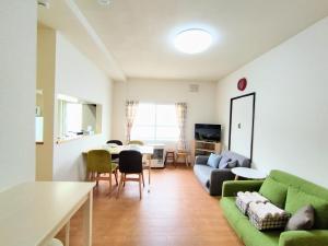札幌Hachiken Chaya 2F 1-6ppl的客厅配有沙发和桌子