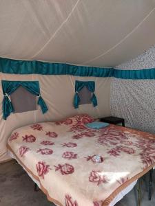 穆索里Mussoorie Camp Resort的帐篷内的一张床位,床上配有带鲜花的床单