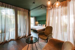 修希Floris Green Suites by Parc Hotel Florian的一间卧室配有一张床、一张沙发和一张桌子