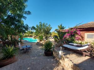 伊法地La Bella Donna的度假庭院设有游泳池和桌椅