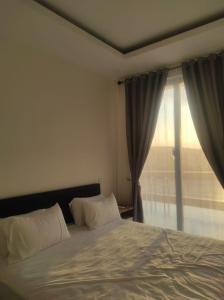 巴淡岛中心Santai Homestay Batam的一间卧室设有一张床和一个大窗户