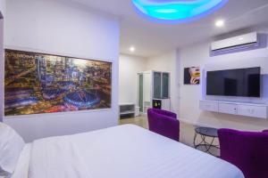 芭堤雅市中心titanic residence的卧室配有白色的床和平面电视。