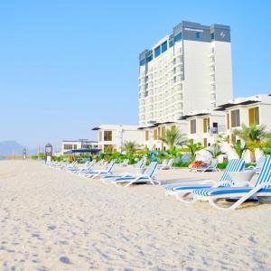 迪巴Mirage Bab Al Bahr Beach Hotel的海滩上一排躺椅