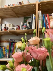 东港风宿-环岛东港站 的书架前方的花瓶,有粉红色的花朵