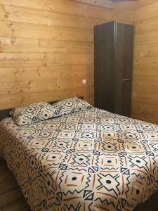 AlièzeForest Jura Lodge - Chalet des sapins的一间卧室配有一张木墙床