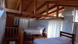 MarantochoriKassi's House的一间卧室设有两张床和木制天花板