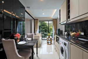苏林海滩Panora Surin by Holy Cow, 1-BR, mountain view的厨房以及带洗衣机和烘干机的客厅。
