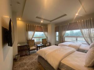 伊斯兰堡Sintra Hotel的酒店客房设有两张床和窗户。