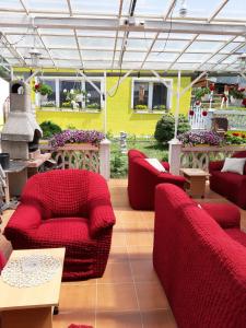 赫拉布斯Villa Vraji的庭院配有红色的椅子和桌子