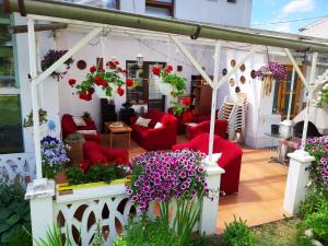赫拉布斯Villa Vraji的庭院里摆放着红色的沙发和鲜花