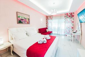 尼基季Dream Boutique Apartments的卧室配有一张带红色毯子的白色床