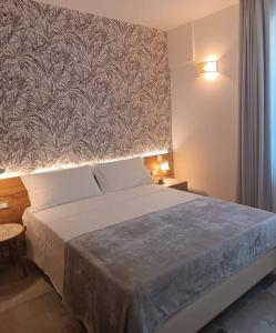 切塞纳蒂科Le stanze di Diana的一间卧室设有一张大床和大墙