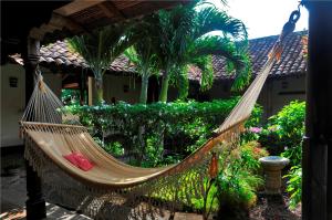 格拉纳达Hotel Patio del Malinche的棕榈树屋前的吊床