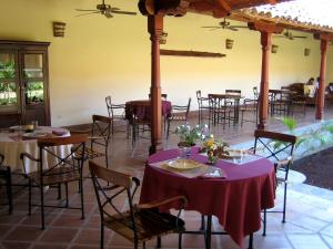 格拉纳达Hotel Patio del Malinche的餐馆里的一组桌椅