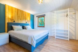 拉罗什-阿登Bills Lodge, le plaisir de la rivière à 2 minutes du centre!的卧室配有蓝色和白色的床和窗户。