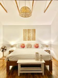 新孔Nibbana Bungalows的白色卧室配有一张大床和一张桌子