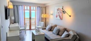 罗希姆诺Ammos Suites的带沙发的客厅,享有海景