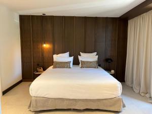 维琪奥港Hôtel Spa & Restaurant - Son de Mar的卧室配有一张白色大床和木墙