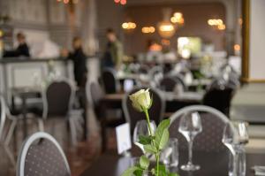 恩舍尔兹维克First Hotel Statt Örnsköldsvik的餐厅的桌子上花瓶里的玫瑰