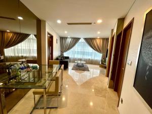 吉隆坡Vortex Suites KLCC by Nadia Guesthouse Kuala Lumpur的一个带玻璃桌的大堂和一间客厅