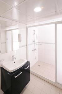 高雄奇异果快捷旅店-高雄车站店的白色的浴室设有水槽和淋浴。