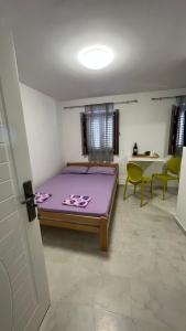 布德瓦T&S ROOM的一间卧室配有一张紫色的床和一些椅子