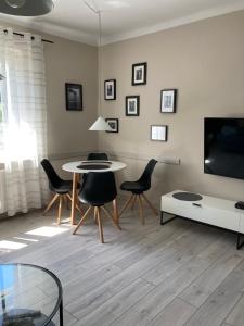 华沙Apartament Młociny的客厅配有桌椅和电视。