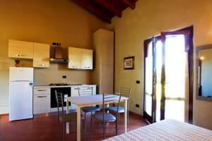 卡斯泰内多洛B&B Cascina Quaderna的厨房配有桌椅和白色冰箱。