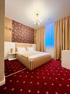 尼古拉耶夫Sergeev Hotel的一间卧室配有一张大床和红地毯