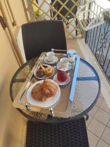 特罗佩阿Ninfea Tropea City Rooms的阳台上的一张桌子和糕点托盘