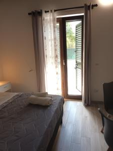 卡梅罗塔码头B&B JoseyMaria的一间卧室设有一张床和一个大窗户